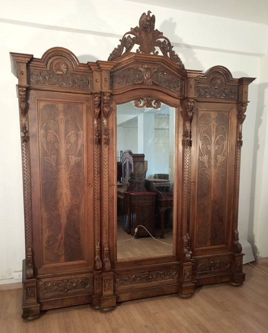 Antieke Italiaanse houten kledingkast in renaissancestijl met sierlijk houtsnijwerk en een spiegel in het midden, eind 19e eeuw.