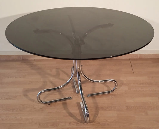 Salontafel uit het midden van de vorige eeuw, gemaakt van verchroomd staal met een rond blad van zwart rookglas, elegant Italiaans design.