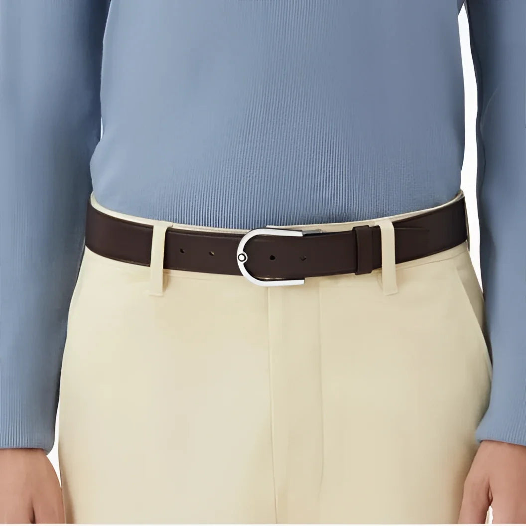 Montblanc cintura 35mm in pregiata pelle granulata ebano con fibbia ferro di cavallo indossata su maglione blu e pantaloni beige