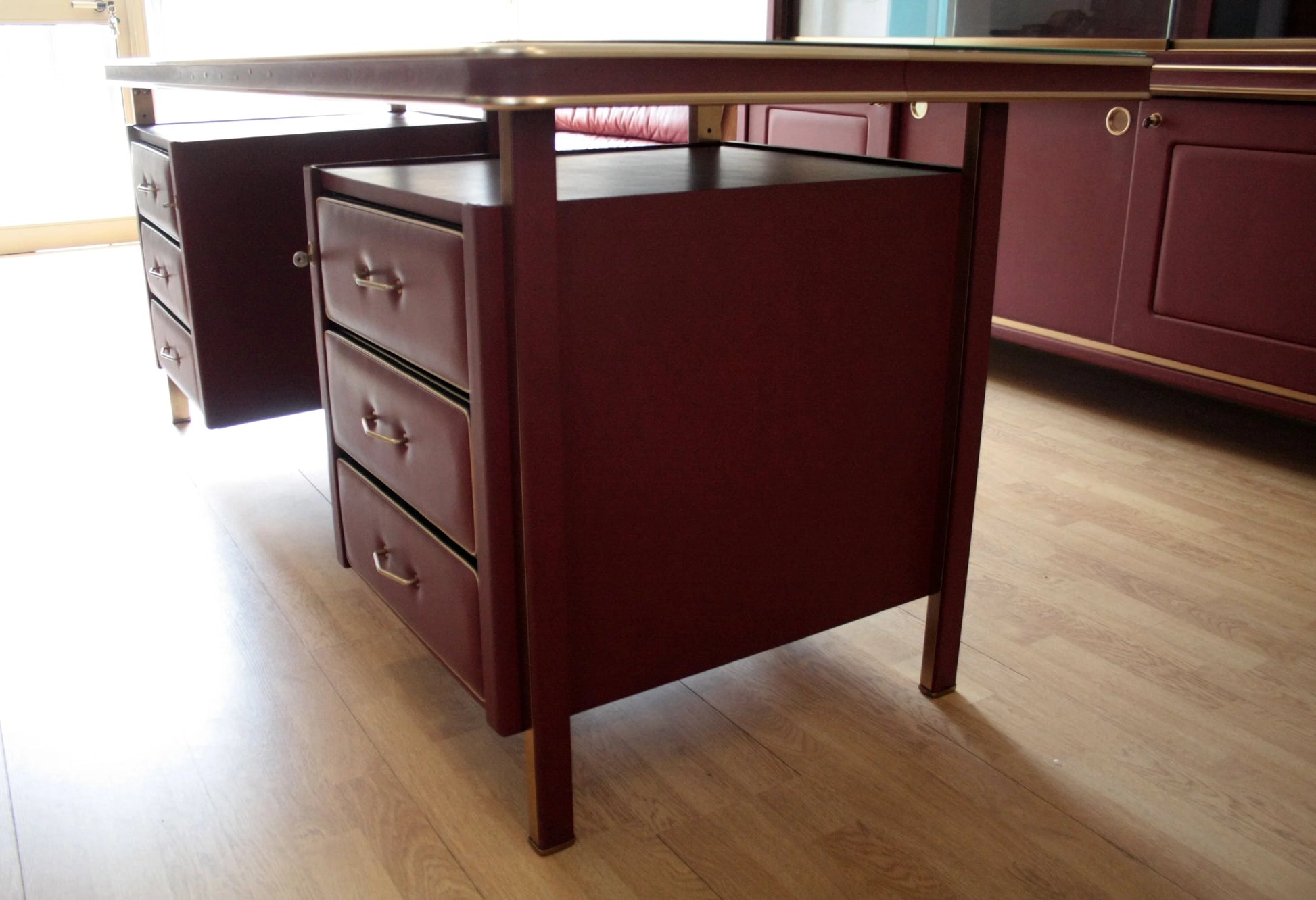 Scrivania ministeriale disegnata da umberto mascagni in similpelle bordeaux con cassetti in ottone, 1950 italia