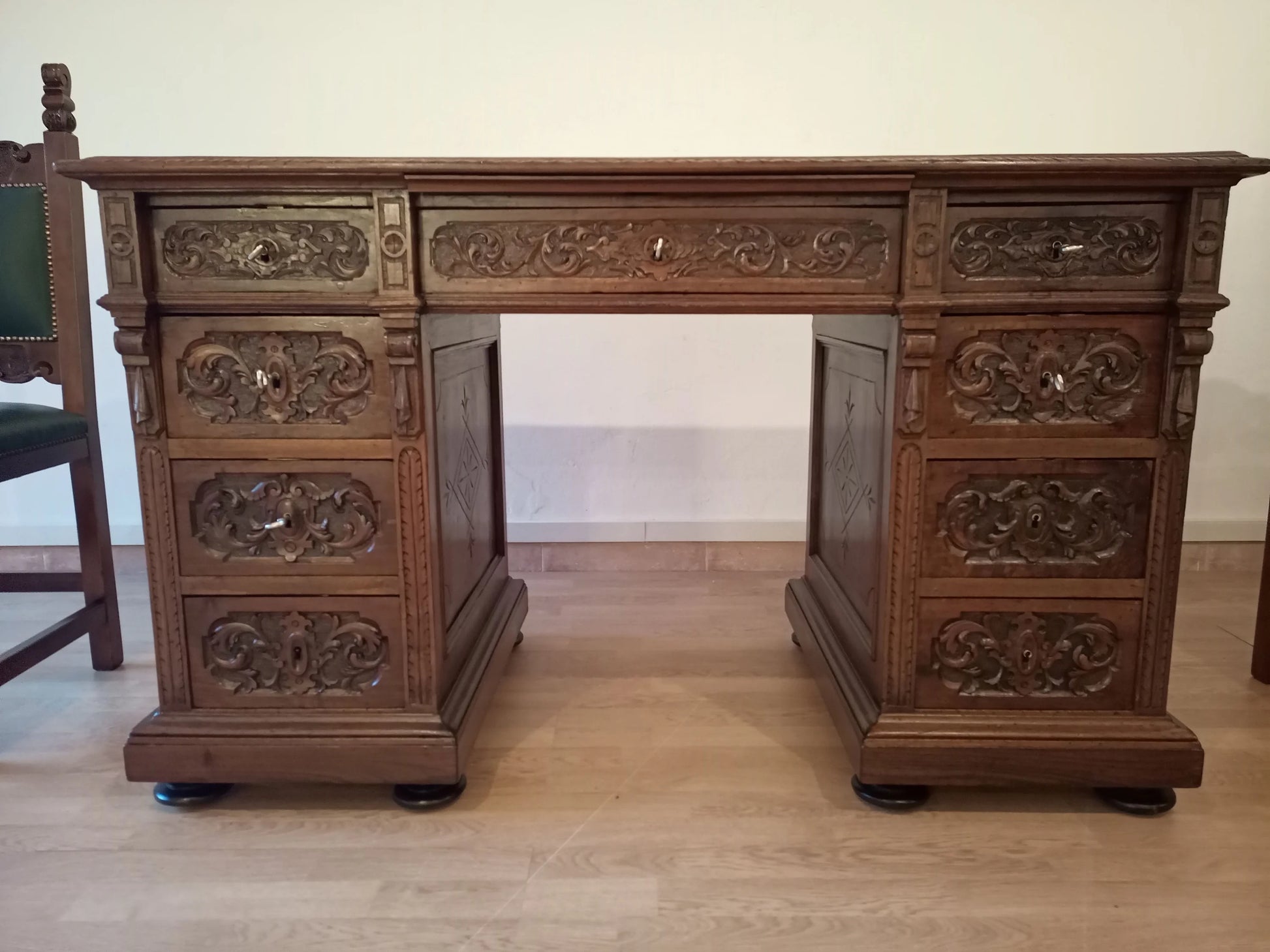 Scrivania ministeriale in noce con intagli ornati, cassetti multipli e pannelli decorativi per studio stile eclettico